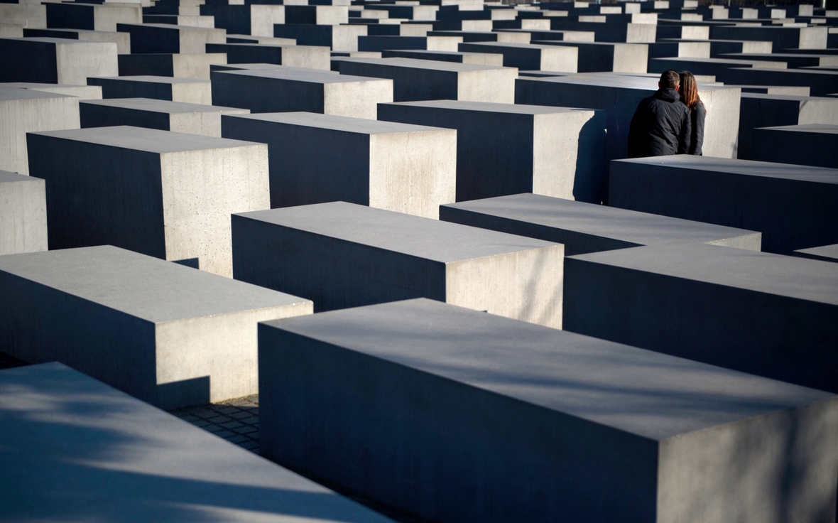 Besucher betrachten das Holocaust-Mahnmal in Berlin