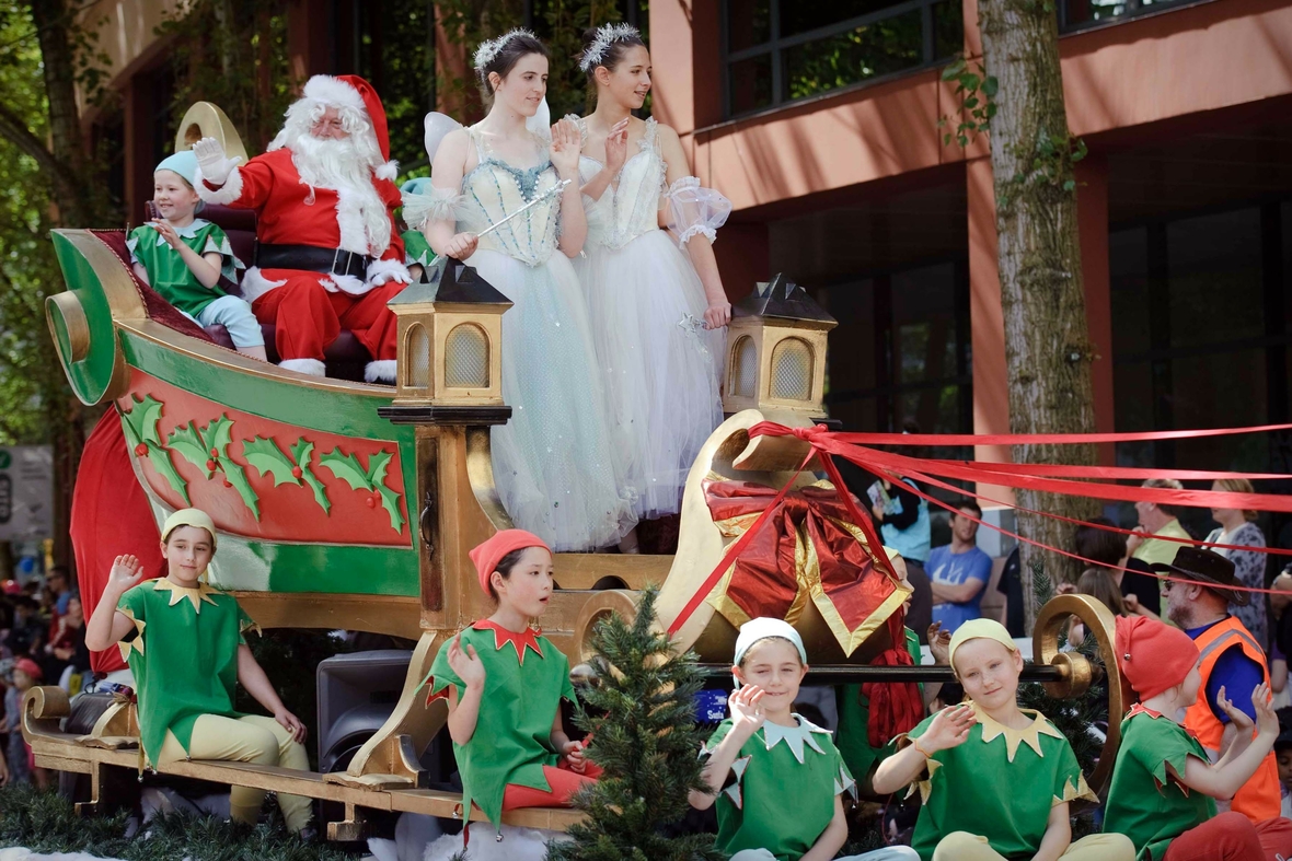 Ein als Weihnachtsmann verkleideter Mann winkt am 14.12.2013 in Wellington während der "Waitomo District Christmas Parade"-Weihnachtsparade aus einem festlich geschmückten Umzugswagen. Bei sommerlichen Temperaturen im Dezember kommt der Weihnachtsmann in Neuseeland durchaus mal ins Schwitzen.