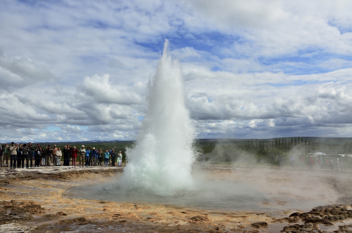 Im Süden von Island schauen sich Touristen den Geysir Strokkur an.