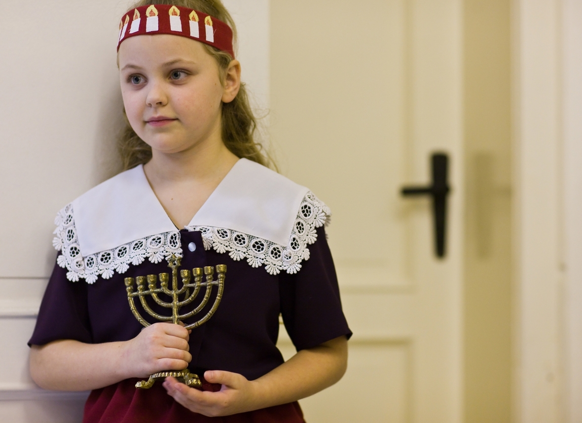 Mädchen wartet mit einem Chanukka-Leuchter auf den Beginn des jüdischen Lichterfests in der jüdischen Gemeinde von Frankfurt an der Oder.