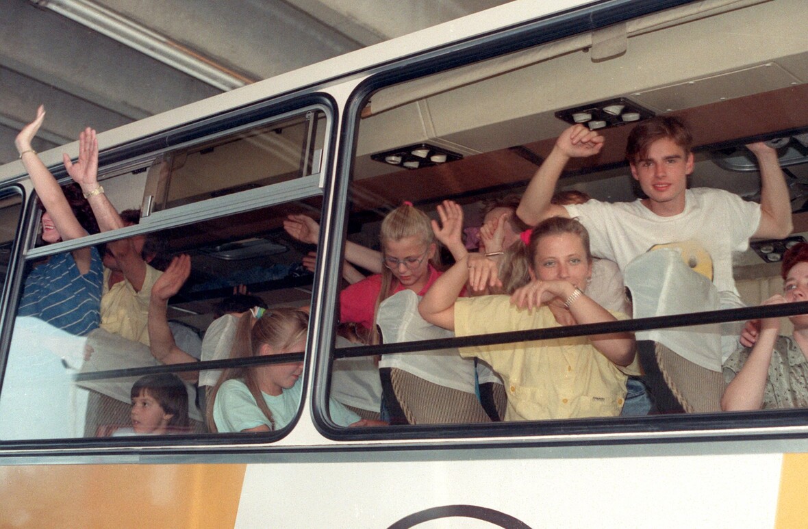 Winkend fahren Menschen aus der DDR im September 1989 über die ungarische Grenze nach Österreich.