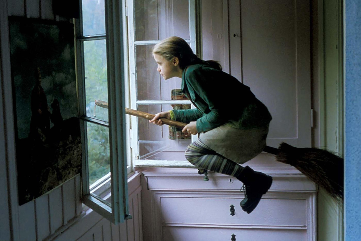 Szenenbild: Die kleine Hexe Bibi Blocksberg fliegt auf ihrem Besen aus dem Fenster