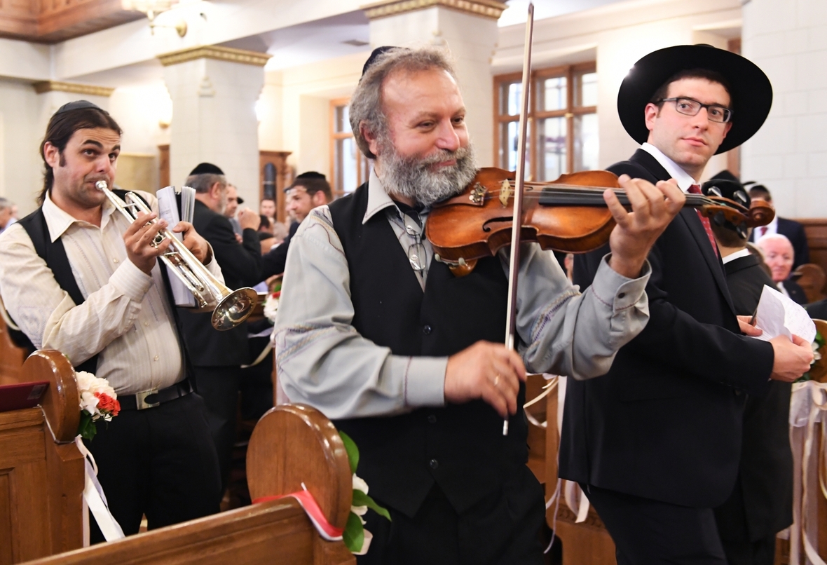 Musikanten spielen bei einer Hochzeit in einer Synagoge.