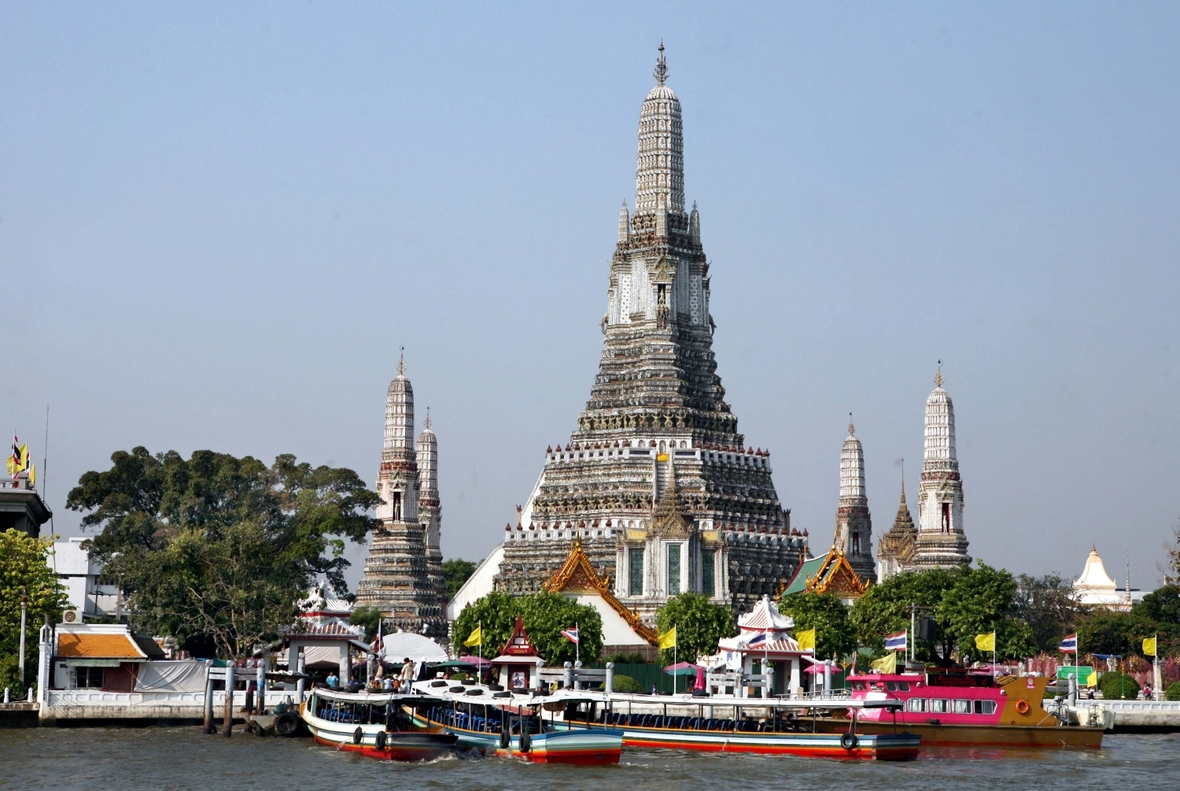 Touristenboote vor einem buddhistischen Tempel in Bangkok. „Wat Arun“ gehört zu den Wahrzeichen der Stadt.