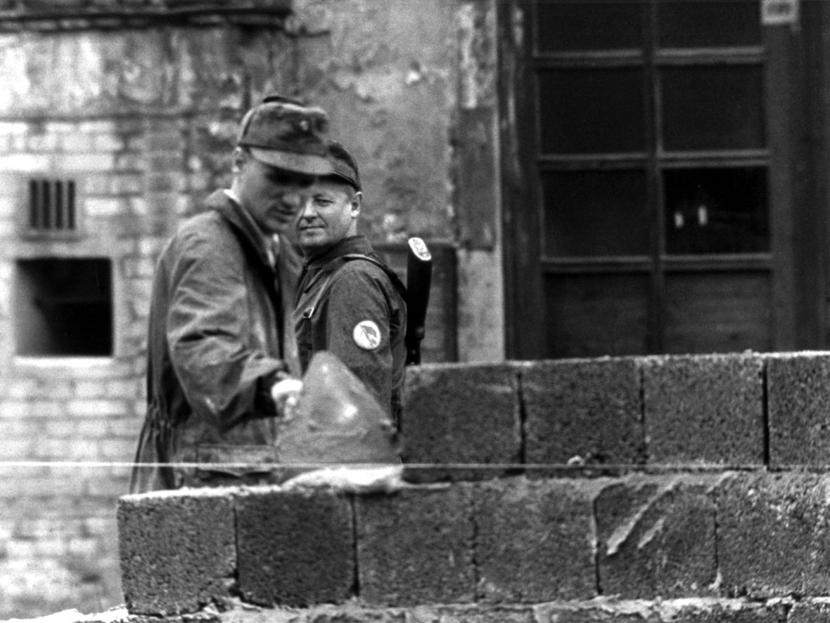 Unter Aufsicht der Volkspolizei wird die Berliner Mauer am 13. August 1961 gebaut.