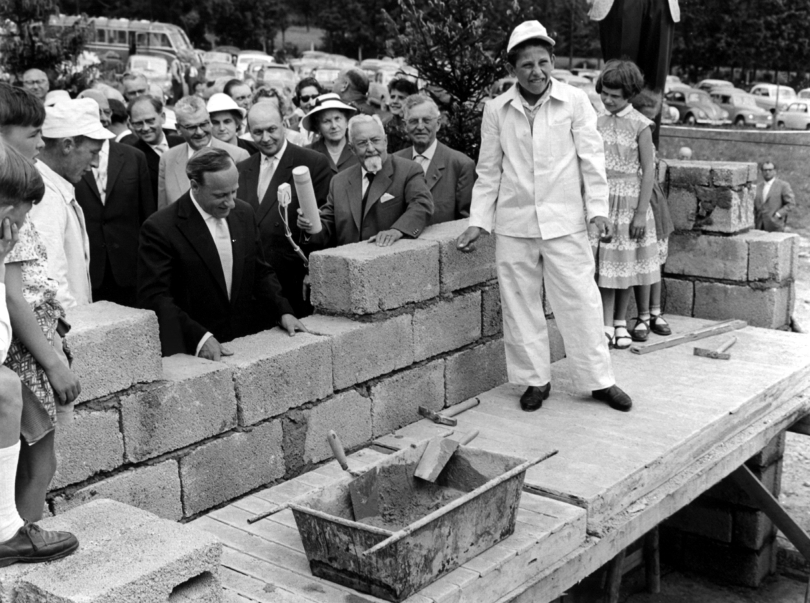Im Jahr 1958 wurde der Grundstein für das Haus des ersten SOS-Kinderdorfes in Deutschland gelegt. Hermann Gmeiner, Gründer der SOS-Kinderdörfer, setzt für das Foto einen Stein ein. 