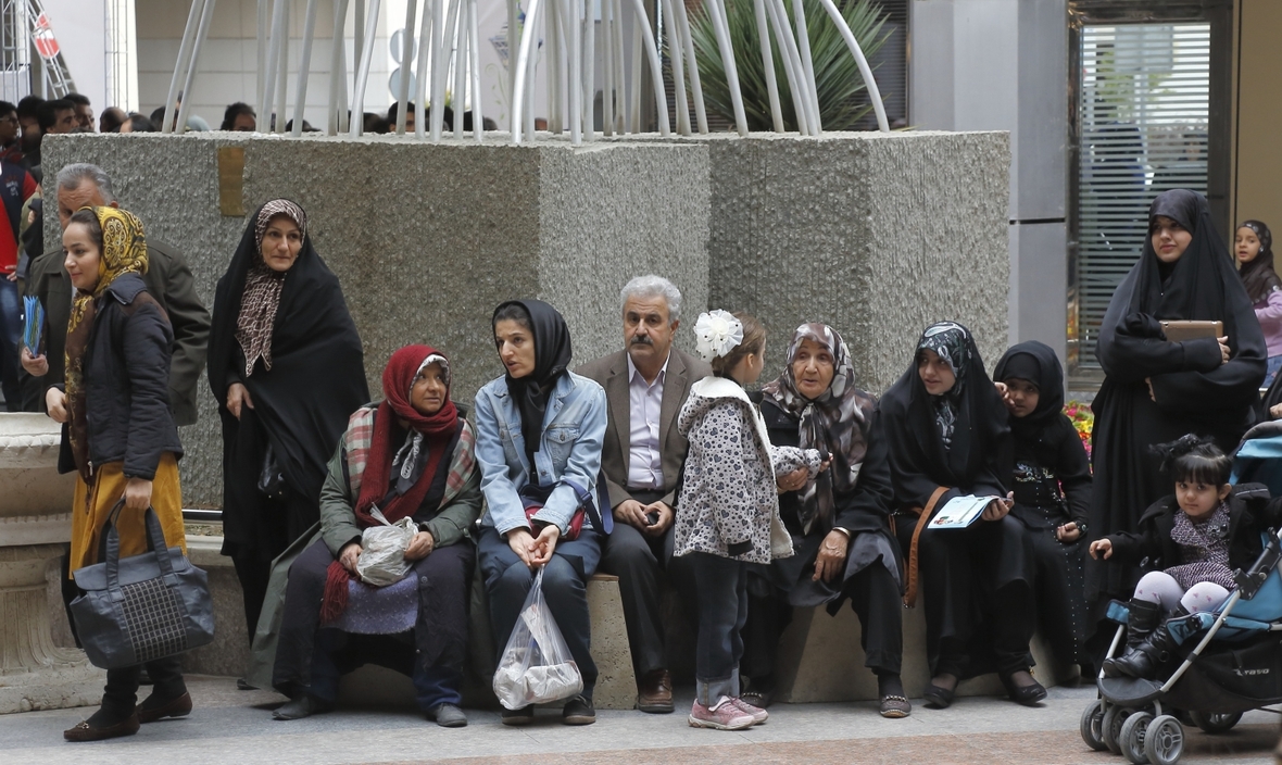 Frauen, Männer und Kinder auf einem Platz in Teheran, Iran.
