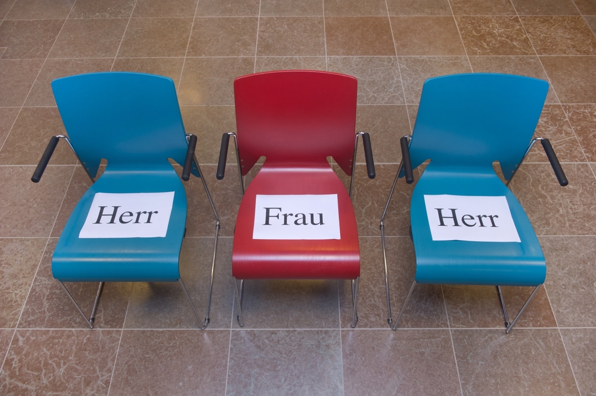 Stühle jeweils mit der Aufschrift "Herr" oder "Frau" sind zu sehen. Sie stehen für das Thema Frauenquote.