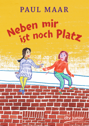 Zwei Mädchen sitzen auf einer Mauer.